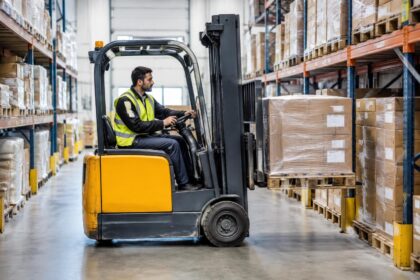 Carretilla elevadora trabajando entre estanterías en un almacén